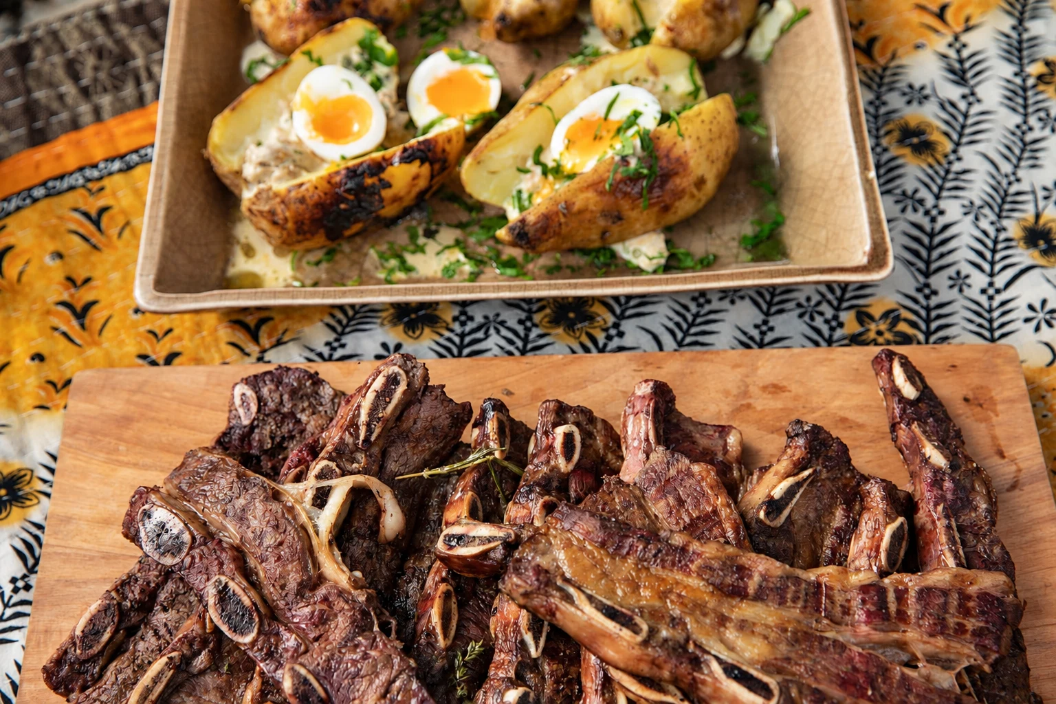 Asado de tira sobre tabla con papas y huevo · fotografía mejorada